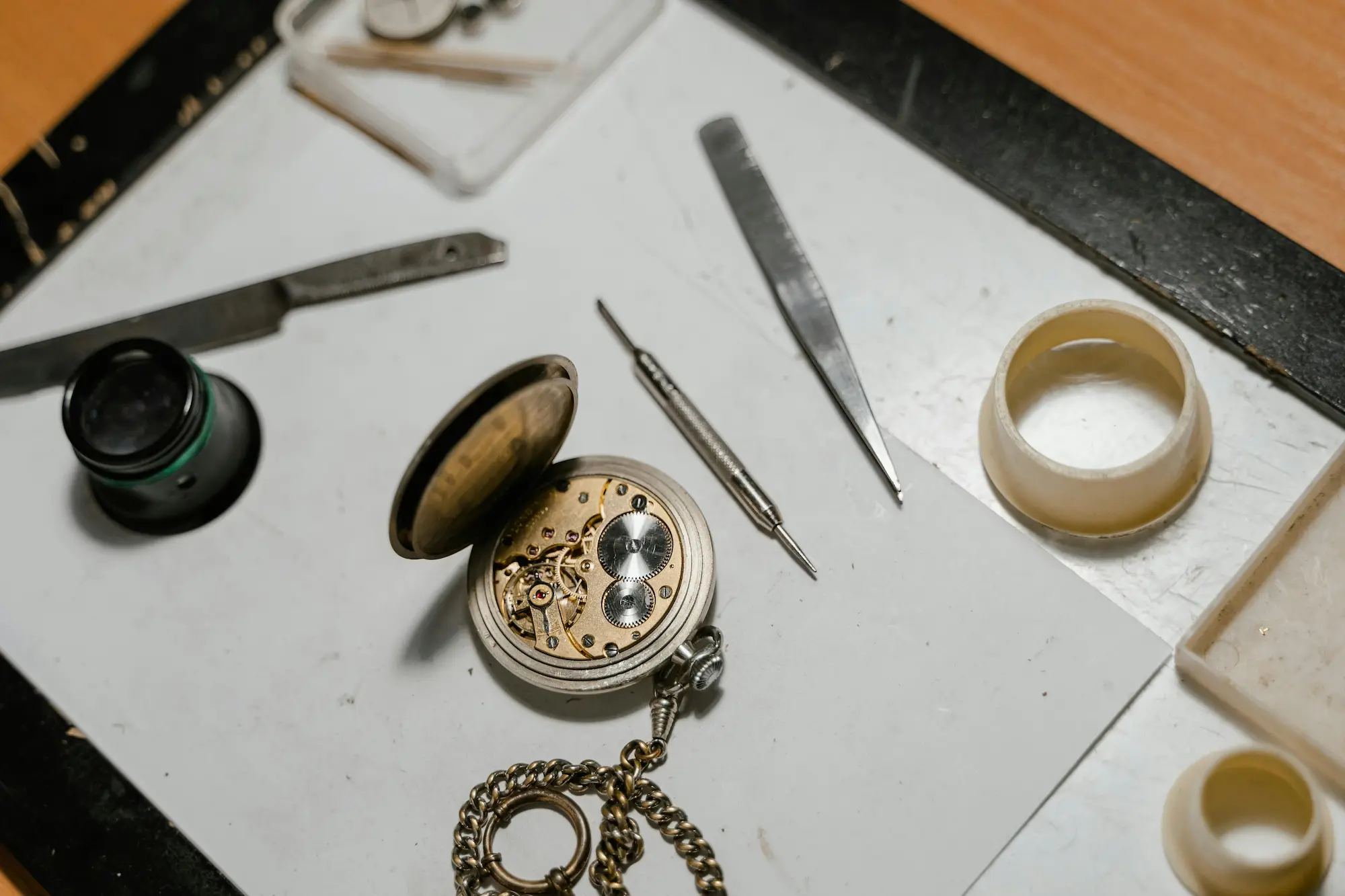 Uhrmacherwerkzeug neben einer geöffneten mechanischen Armbanduhr