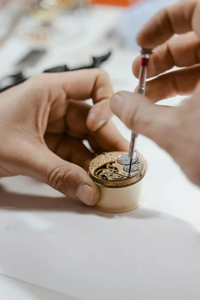 Geöffnetes Uhrgehäuse mit Dichtung und feinen Schrauben